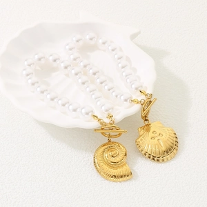 Detail of gold seashell and starfish charms on a pearl bracelet with OT toggle clasp