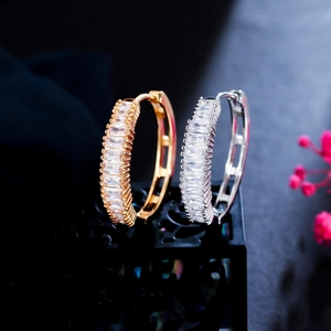 Macro shot of gold and silver hoop earrings with channel-set rectangular cubic zirconia