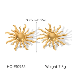 Detailed close-up of golden sunburst stud earrings with polished wavy rays