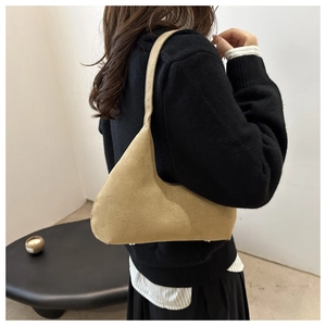 Side view of khaki matte suede shoulder bag showing silhouette and strap detail on model