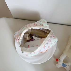 Detail view of pink floral quilted cotton pouch showing interior storage and zipper