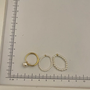 Three-piece set of elegant freshwater pearl elastic rings shown on a measuring tool
