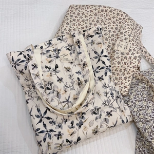 Three cotton canvas tote bags with floral and leaf prints on a quilted background