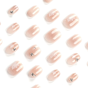 Elegant gradient pink press-on nails with white floral designs and subtle glitter accents