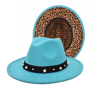 Detail of teal wide brim fedora hat featuring pearl band and leopard print lining