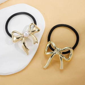 Minimalist elastic hair tie set with golden metallic bow and pearl accents on white stone