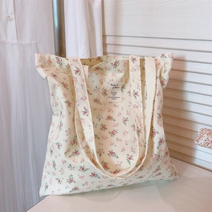 Detail of floral canvas tote bag with pink flower print and white woven label