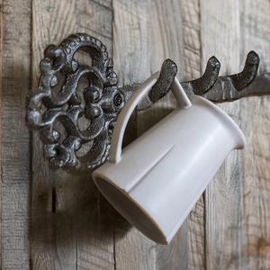 Vintage key shaped cast iron wall hooks with scrollwork design and ceramic mug hanging