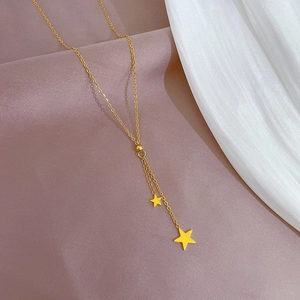 Close-up of golden tassel star pendant necklace on elegant pleated silk fabric background