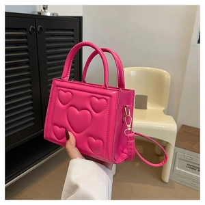 Détail du mini sac à main rose vif avec motif de cœur 3D et accessoires dorés