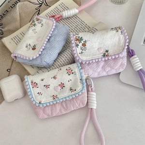 Detailed close-up of quilted floral fabric pouches with heart buttons and tassels