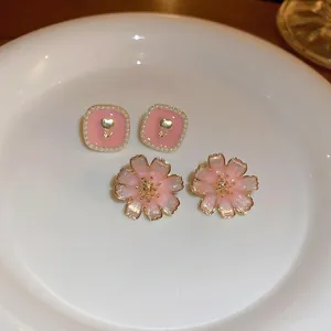 Pink floral and square pearl stud earring set with gold tulip relief on a white plate