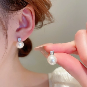 Elegant silver zircon and pearl drop earrings shown on model for a classic french style
