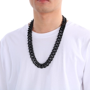 Close-up of a bold black stainless steel Cuban link chain necklace worn on a white t-shirt