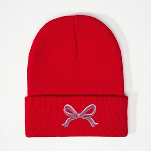 Red knit beanie for women featuring a delicate purple bow embroidery on the cuff