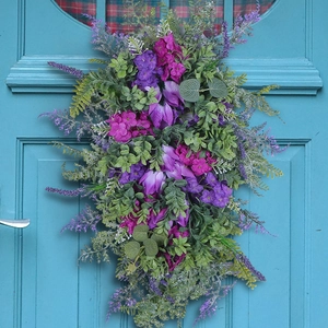 Purple tulip wreath with hydrangea and hyacinth hanging on a vintage wooden door