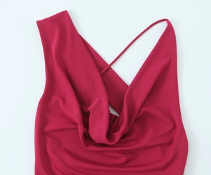 Dettaglio dell'abito magenta con scollo a cappuccio e spalline sottili in tessuto fluido