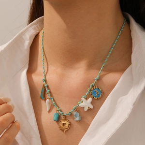 Colorful woven cord necklace with heart, sun and moon pendants on a female model