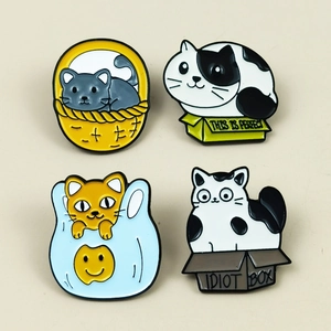 Detail view of 4 cute enamel cat pins in creative boxes and baskets with colorful finishes