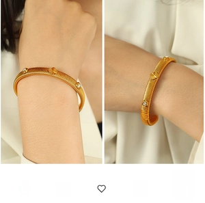 Detail of gold clover bangle with textured vertical patterns and sparkling rhinestones