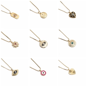 Collection of nine gold necklaces with enamel heart, evil eye, and sunburst pendants