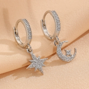 Orecchini asimmetrici stella e luna in argento con pavé di cristalli su sfondo satin