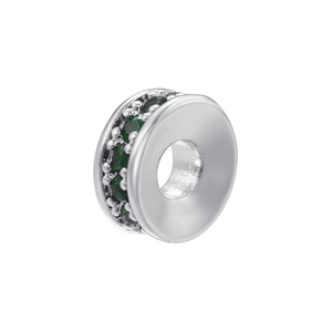 Macro shot of silver plated round spacer bead with emerald green zircon inlay