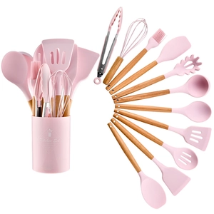 Pink silicone kitchenware set with wooden handles and storage bucket on white background