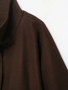Detailed close-up of dark brown wool coat collar and shoulder fabric texture