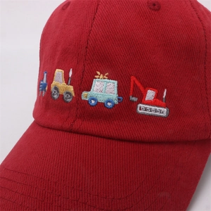 Close-up of red cotton baseball cap featuring detailed construction truck embroidery