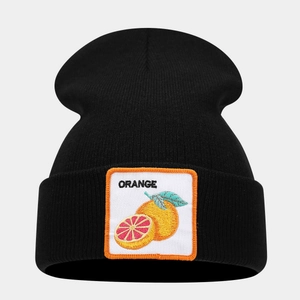 Macro detail of the orange fruit embroidery patch on a black ribbed knit beanie hat