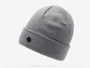 Detail view of dark grey ribbed knit beanie with side cuff and round logo patch