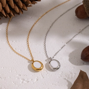 Detail of oval pendants in gold and silver finish on a natural rustic background