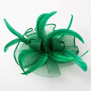 Vintage emerald green fascinator with mesh veil and feathers on a white background