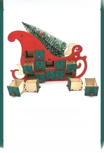 Detail of red wooden Christmas sleigh calendar with numbered green drawers and mini tree