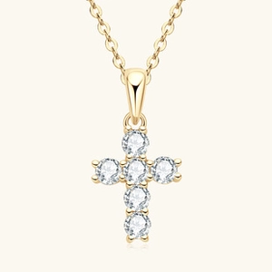 Close-up of gold-finished cross necklace pendant with six round-cut clear gemstones