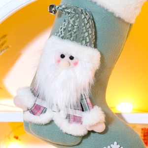 Close-up of green felt Christmas stocking with plush Santa doll and snowflake embroidery