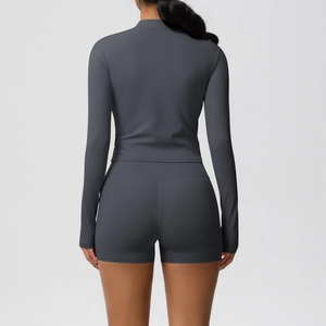 Detail of back seams on high-waist yoga shorts and slim fit long sleeve jacket