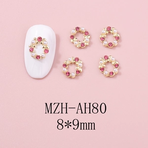 Vue macro des breloques à ongles couronne de Noël avec strass roses et perles