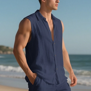 Detail of navy blue sleeveless linen shirt showing breathable fabric texture on a beach