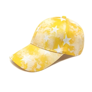 Detail of yellow tie-dye baseball cap with white star prints and twill cotton texture
