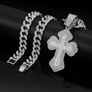 Silver hip hop Cuban link necklace with iced out rhinestone cross pendant on black surface