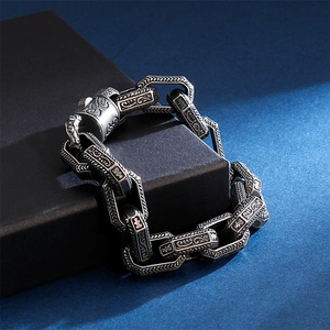Macro shot of retro steel bracelet with gothic engravings on a matte box
