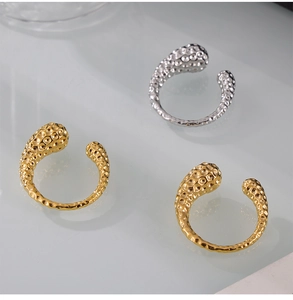 Detailed view of hammered texture on asymmetric gold and silver plated steel rings