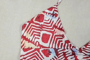 Macro view of geometric red and white pattern on soft satin halter neck dress