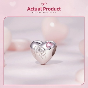 Macro shot of S925 sterling silver heart charm with pink zircon and mother-child design