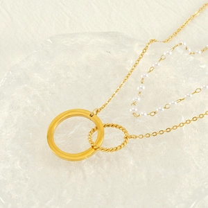Gold double-layered pearl necklace with hollow heart pendant on a glass tray