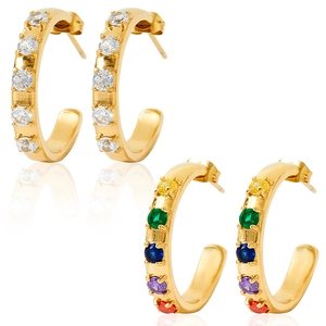 Macro detail of gold C-shaped earrings with sparkling white and multicolor crystals