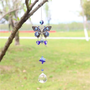 Detailed view of butterfly wind chime with evil eye beads and crystal ball in nature