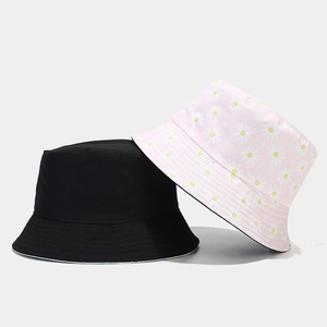 Detail view of cotton bucket hats in classic black and pink daisy floral print pattern